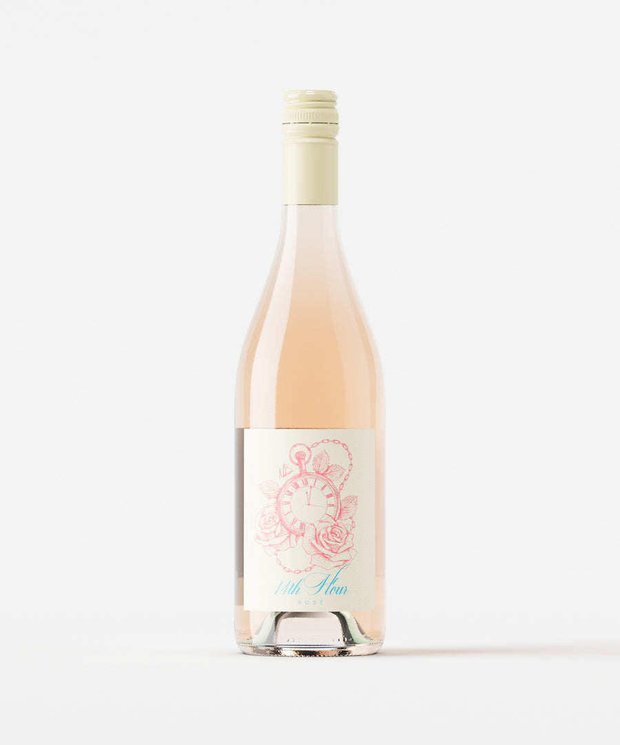 Bottle of 14th Hour Rose wine in burgundy shaped glass on a white background